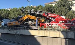 Tırın üzerinden düşen iş makinesi korkuluklarda asılı kaldı