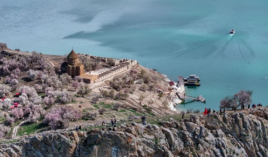 Gevaş ilçesinden 20 dakika süren tekne yolculuğunun ardından ulaşılan ada, Artos Dağı'nda henüz erimeyen kar örtüsü ve badem ağaçlarının oluşturduğu renk cümbüşüyle ziyaretçilerini ağırlıyor.
